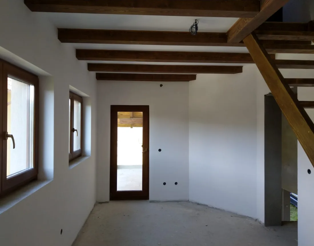 Salón con vigas de madera vistas y paredes recién pintadas