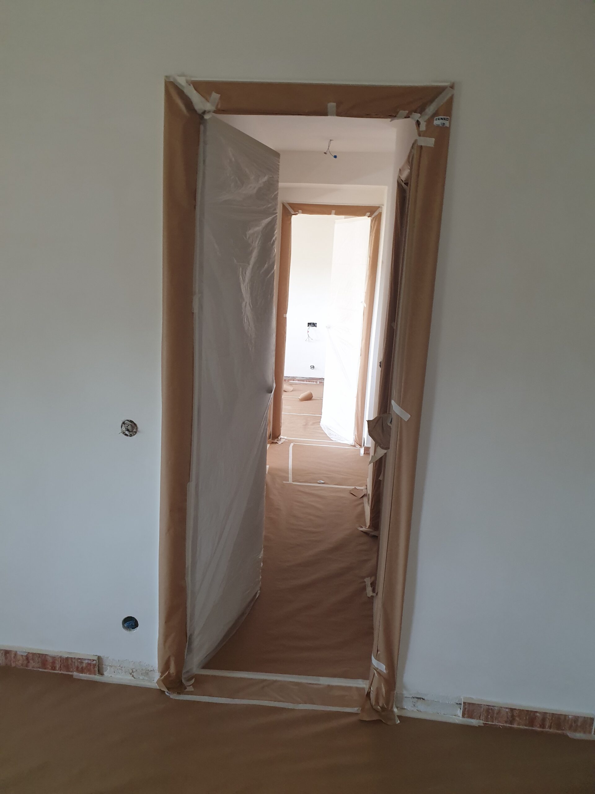 Pasillo con el suelo empapelado y los cercos enmascarados, en una vivienda de Guadarrama