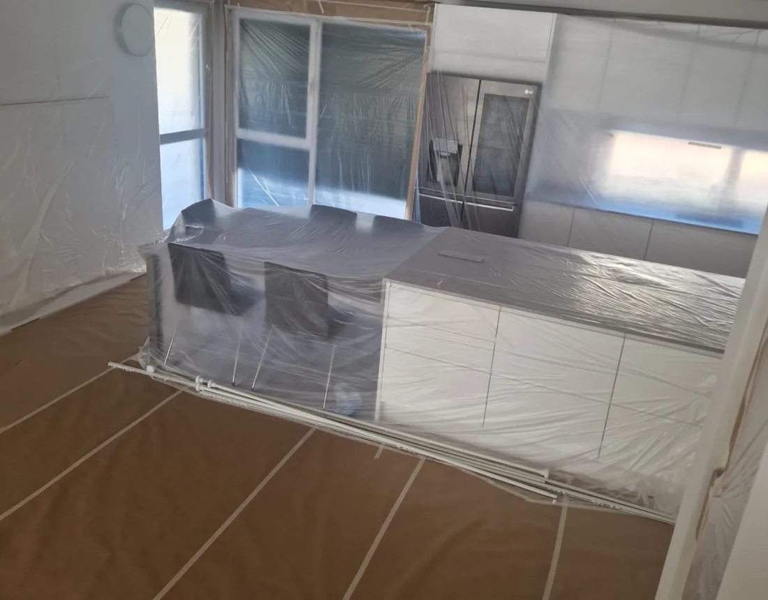 Cocina moderna con la isla y los electrodomésticos cubiertos antes de pintar
