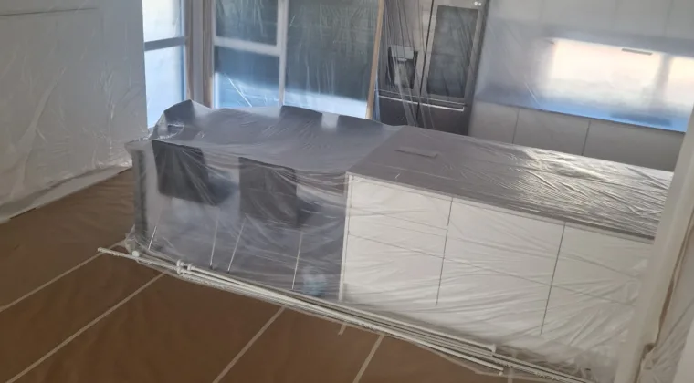 Cocina moderna con la isla y los electrodomésticos cubiertos antes de pintar