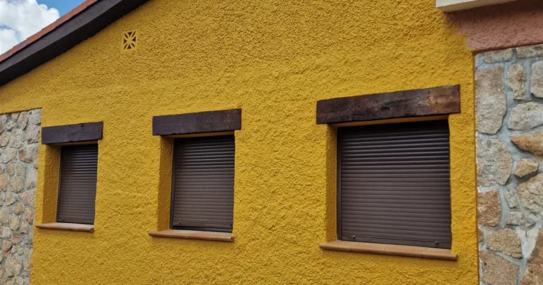 Fachada del chalet de Las Rozas durante la obra, con ventanas enmascaradas y zócalo de piedra protegido