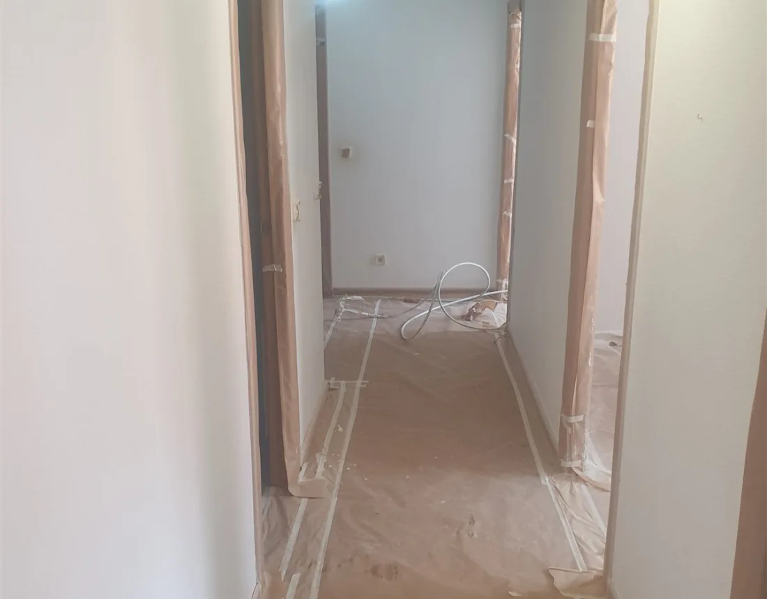 Pasillo de un piso de Collado Villalba con el suelo empapelado y los cercos enmascarados