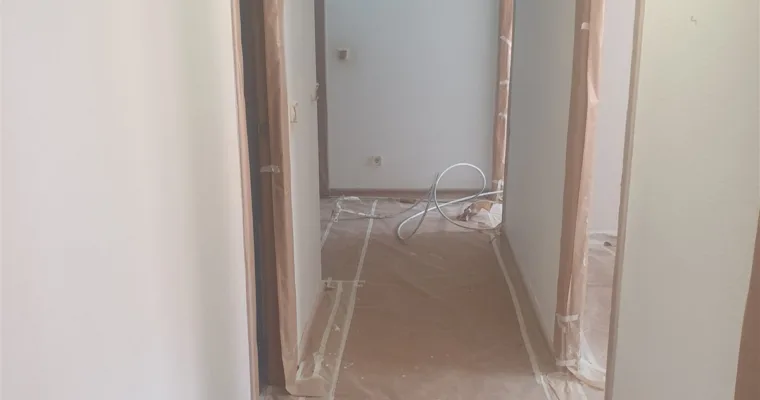 Pasillo de un piso de Collado Villalba con el suelo empapelado y los cercos enmascarados