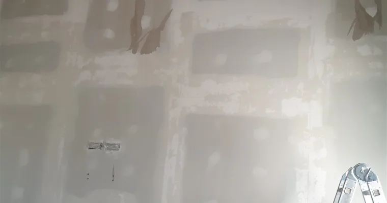 Pared de pladur con juntas y tornillos plastecidos bajo techo de vigas de madera, en un chalet de Torrelodones